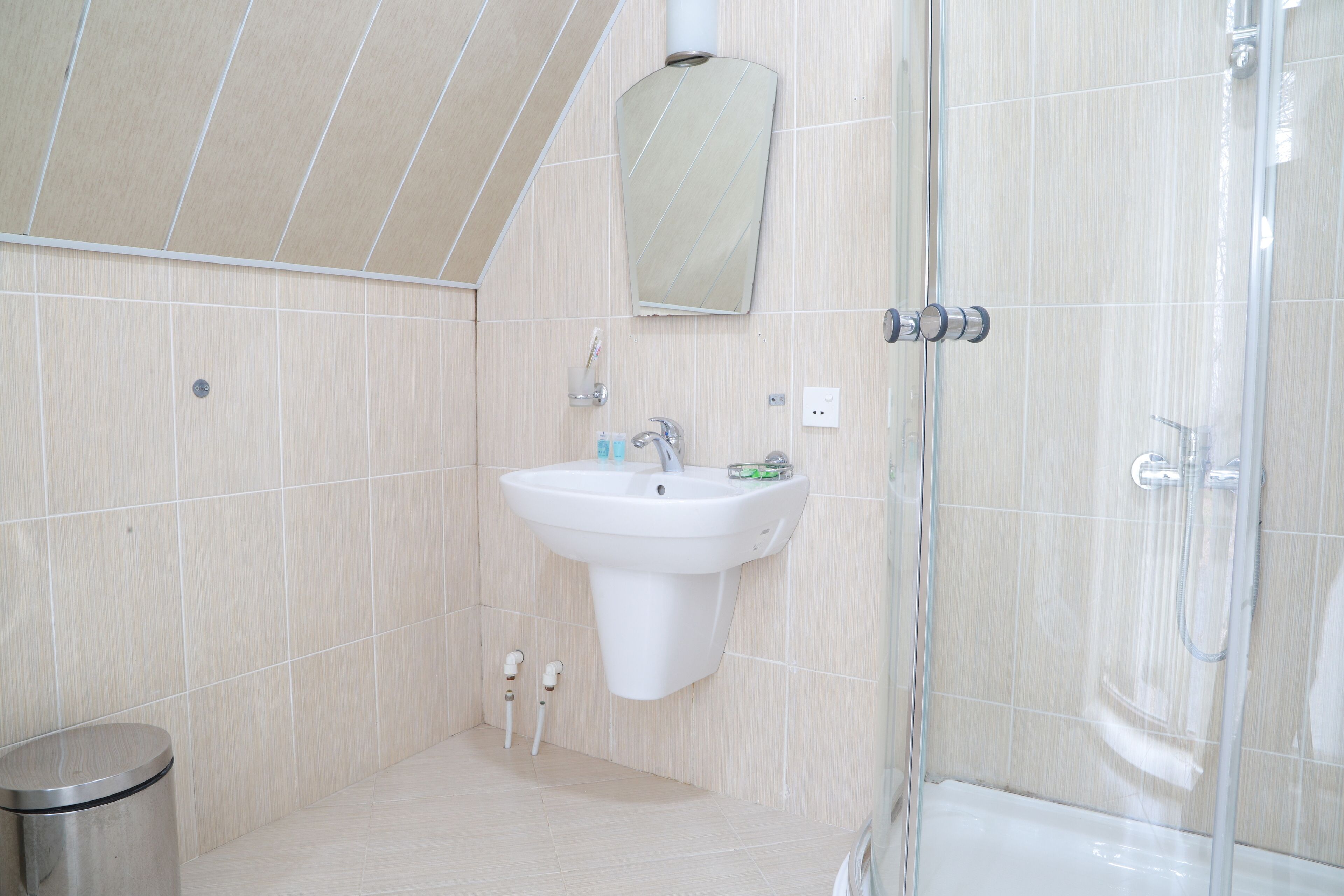 A modern bathroom with a sink, mirror, and shower.