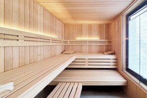 Una sauna con bancos de madera y un ventanal grande.