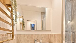 A modern bathroom with a wooden vanity, a large mirror, and a glass shower enclosure. - Magnificent Air-conditioned Flat Galeries Lafayette (Paris)