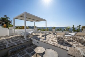 A rooftop terrace with a pergola, seating area, and a view of the landscape. - Il Palazzotto: Historic Residence with Sea View in Ostuni (Ostuni)