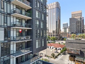 Un immeuble à plusieurs étages doté de balcons, de grandes fenêtres et d’une épingle de localisation rouge.