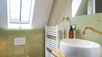 A bathroom with a white sink, a white toilet, and a window.