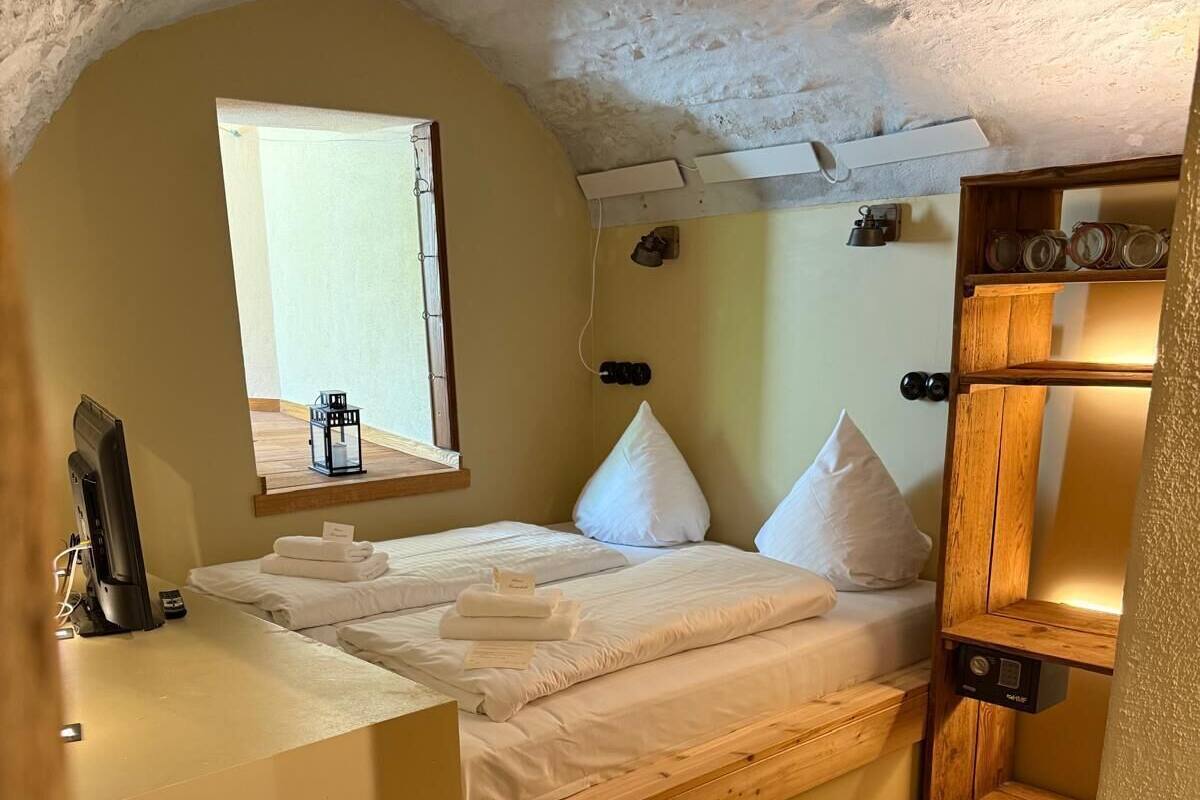 Une chambre confortable avec un lit, un petit bureau et une fenêtre.