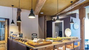 A breakfast bar with wooden crates for dishes, hanging pendant lights, and a rustic ceiling. - Boutique-Hotel Stadtherberge Wetzlar (Wetzlar)