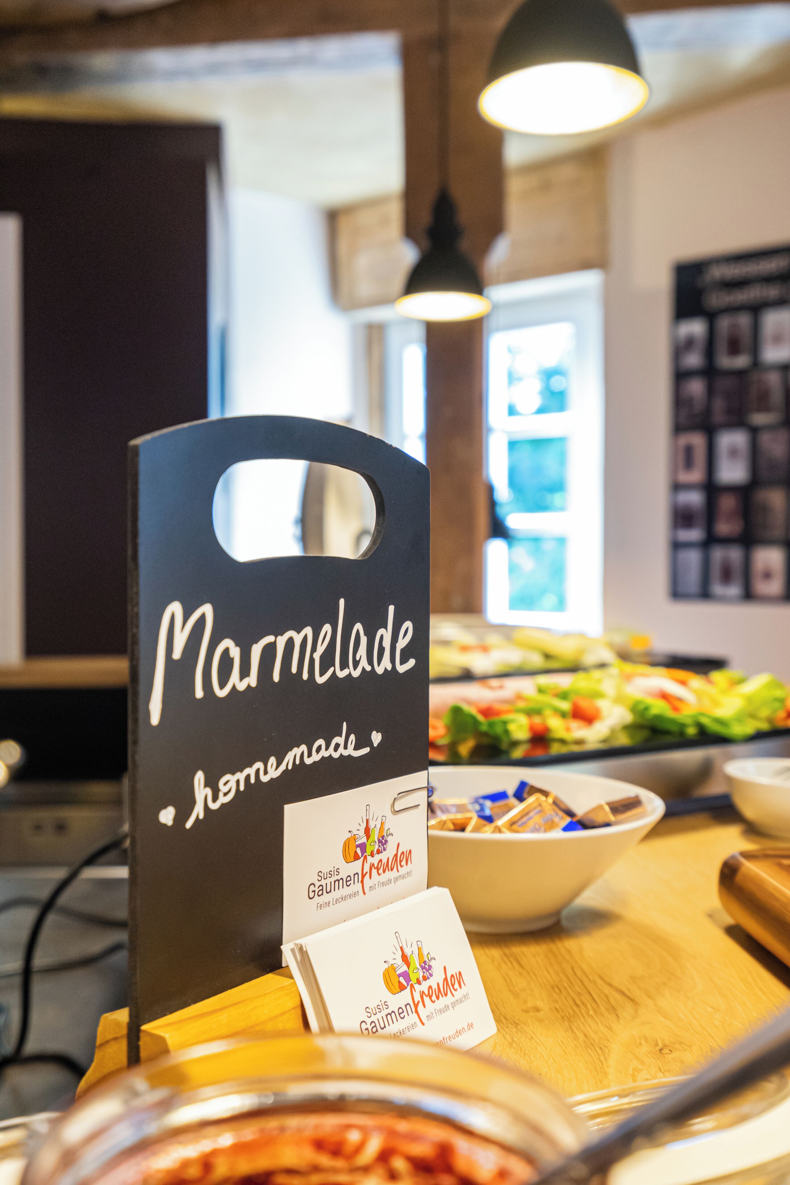 Une pancarte pour « Marmalade », avec une poignée, une petite carte avec du texte et un bol de nourriture sur une table.