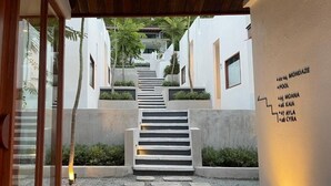 A modern hotel entrance with a staircase leading to a pool area. - Pichcha Kohlarn (Koh Lan)