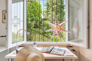 A room with a desk, a star-shaped paper decoration, a hat, and a book.