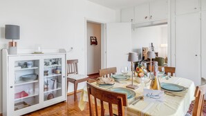A dining area with a table set for four, a cabinet with glass doors, and a 'Welcome' sign. - Family Villa - Casa Nido - Panoramica (Lugano)