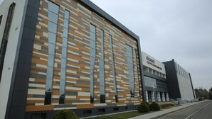Un edificio moderno con facciata a motivi geometrici, ampie finestre e una insegna che indica che si tratta di una scuola.