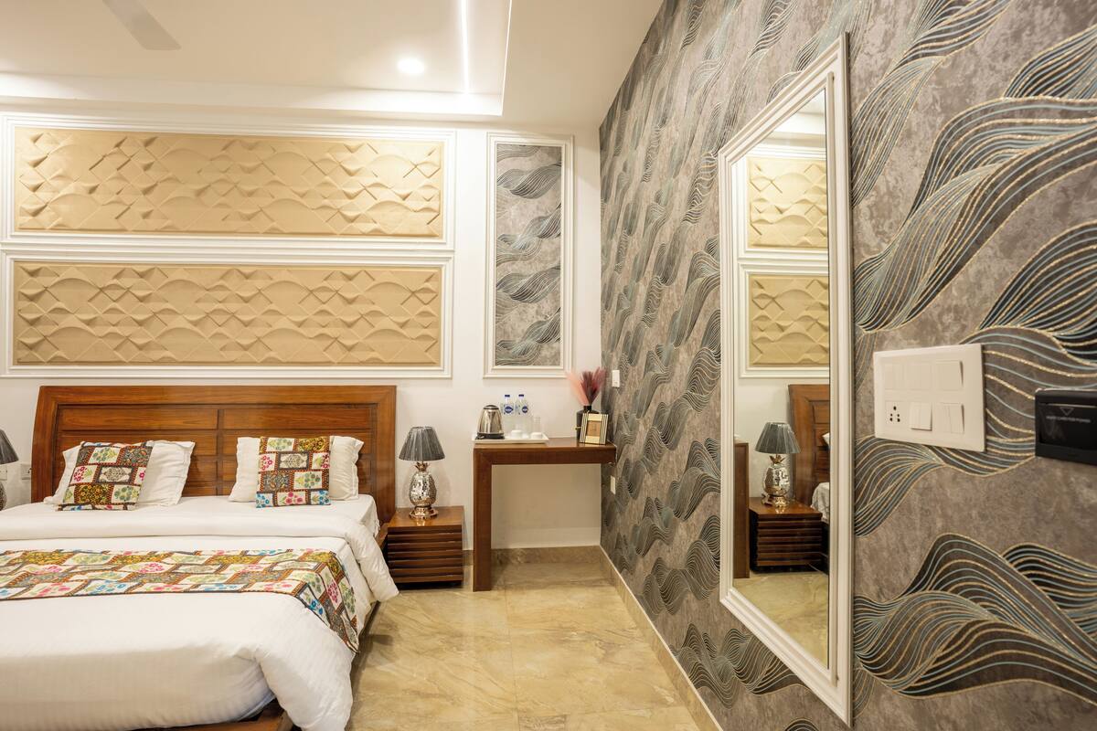 Une chambre à coucher avec un grand lit, une table de chevet, un miroir et un mur orné de panneaux décoratifs.