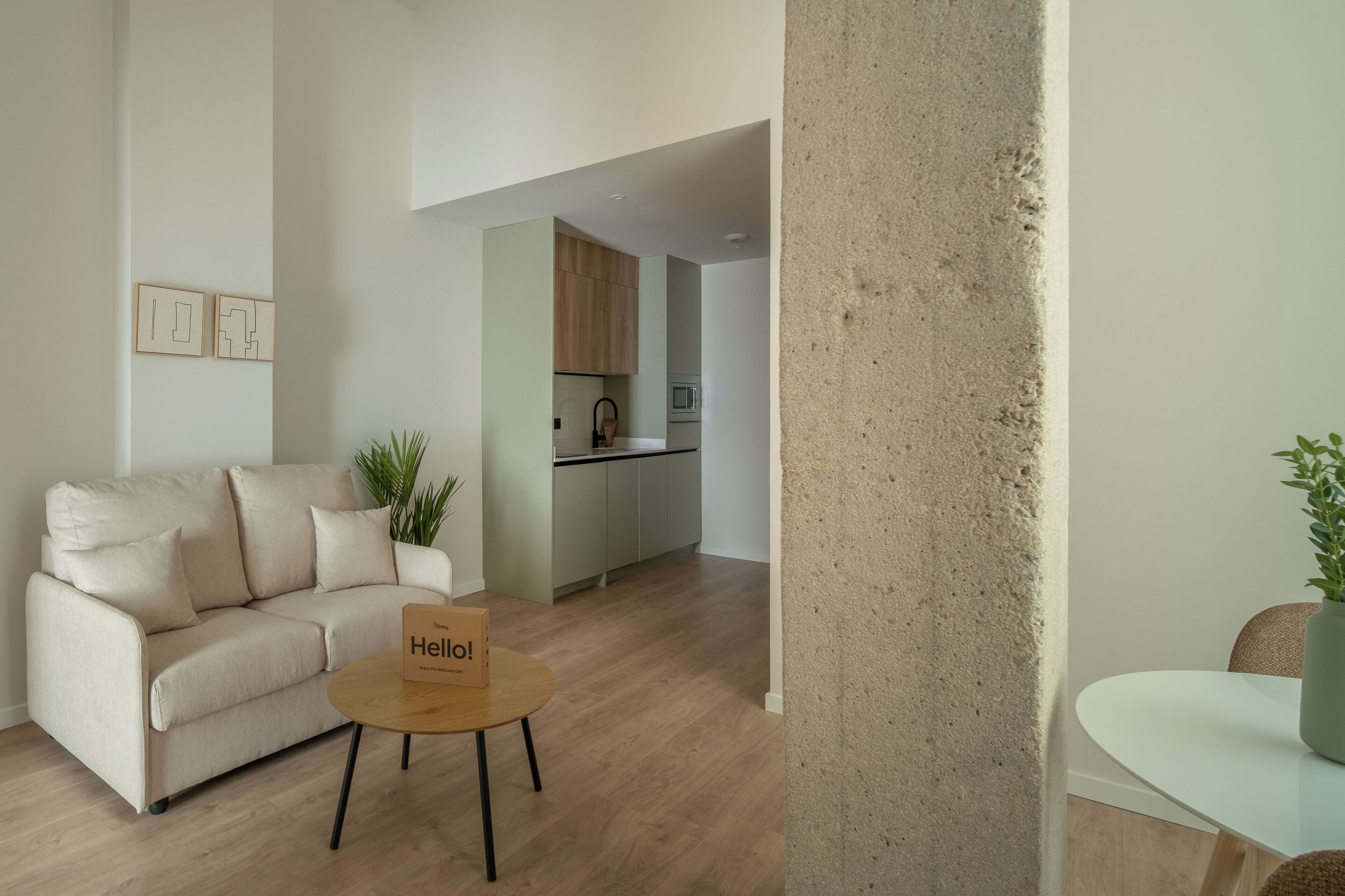 Una sala de estar moderna con un sofá, una mesita de centro y un letrero que dice '¡Hello!'.