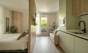 Un appartement moderne comprenant un coin cuisine, un espace repas et une chambre.