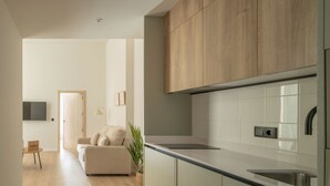 A modern kitchen with wooden cabinets, a stainless steel sink, and a light-colored countertop. - Líbere Pamplona Universidad (Pamplona)