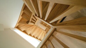 A spiral staircase with wooden railings and a skylight at the top. - Líbere Pamplona Universidad (Pamplona)