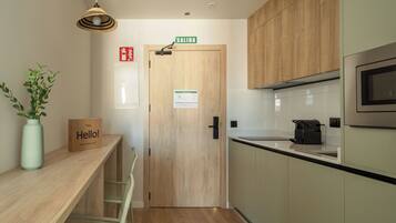 A modern kitchen with wooden cabinets, a microwave, and a 'SALIDA' sign above the door.