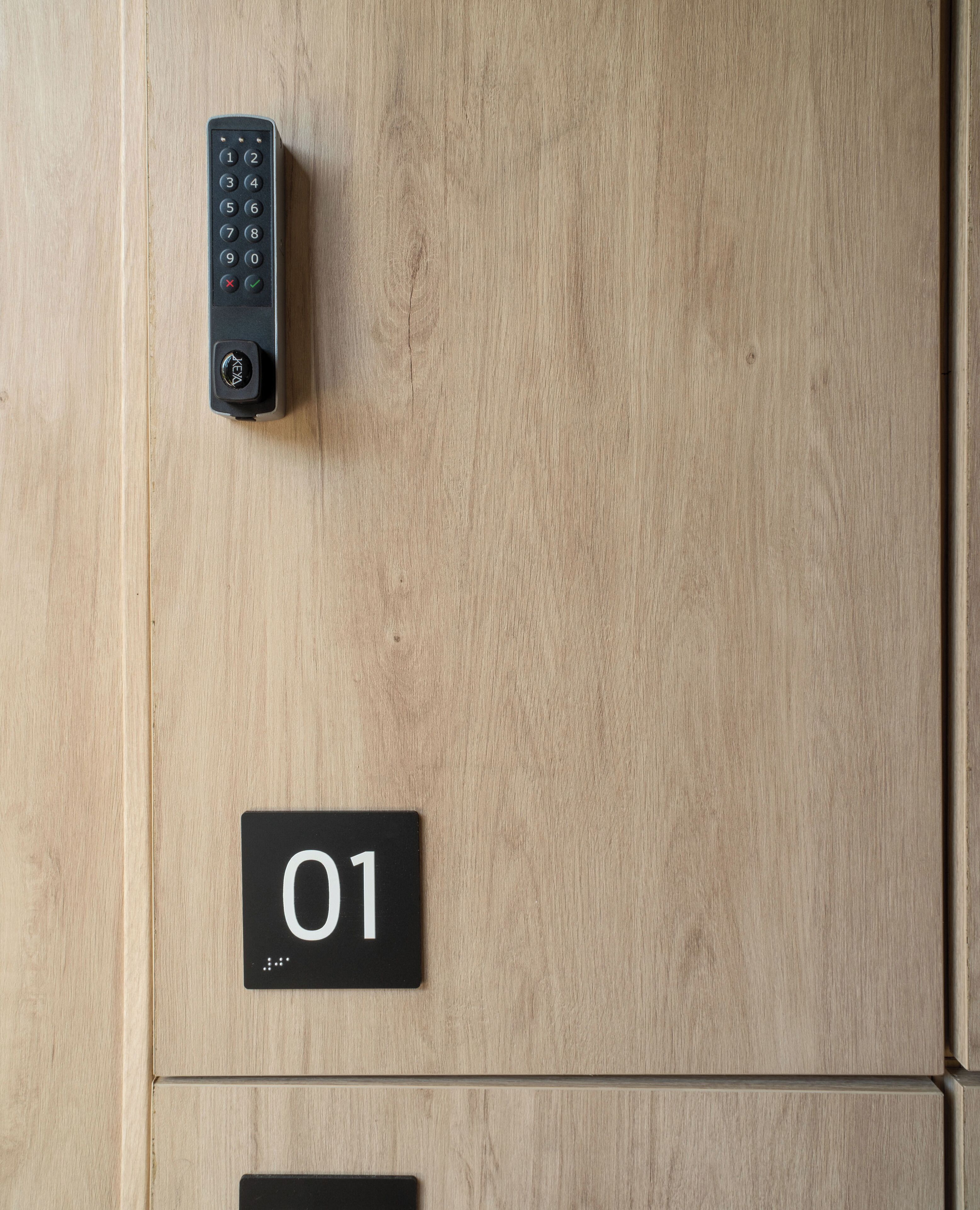A wooden door with a keypad lock and a sign indicating room number 01.