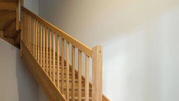 A wooden staircase with a handrail, leading to an upper floor.