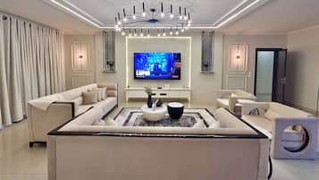 Apartament superior, vistes a la ciutat | Sala d'estar | Televisor de pantalla plana de 50 polzades amb canals per satèl·lit