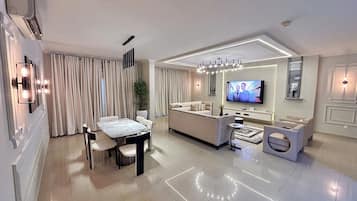 Apartament superior, vistes a la ciutat | Sala d'estar | Televisor de pantalla plana de 50 polzades amb canals per satèl·lit