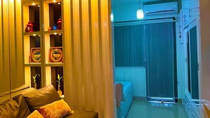 Un salon moderne avec un canapé, des étagères décoratives et un lustre.