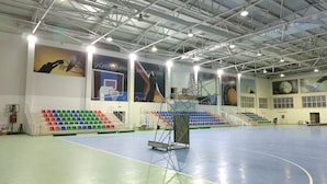 An indoor sports hall with a basketball court, seating areas, and banners. - Arena Hotel Shagan (Baku)