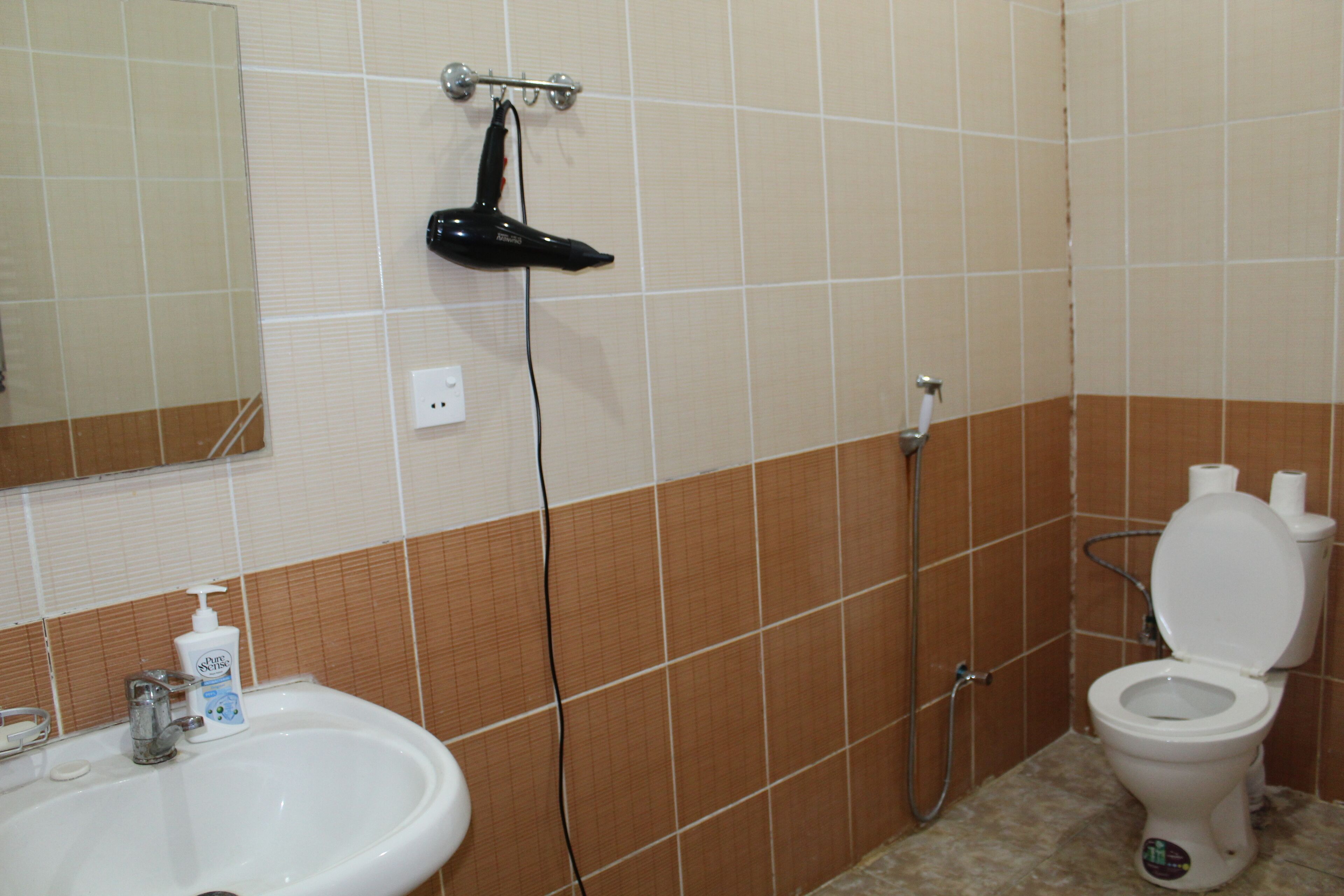 Un baño con lavamanos, espejo y retrete.