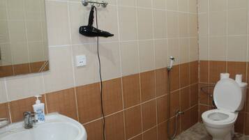 Un baño con lavamanos, espejo y retrete.