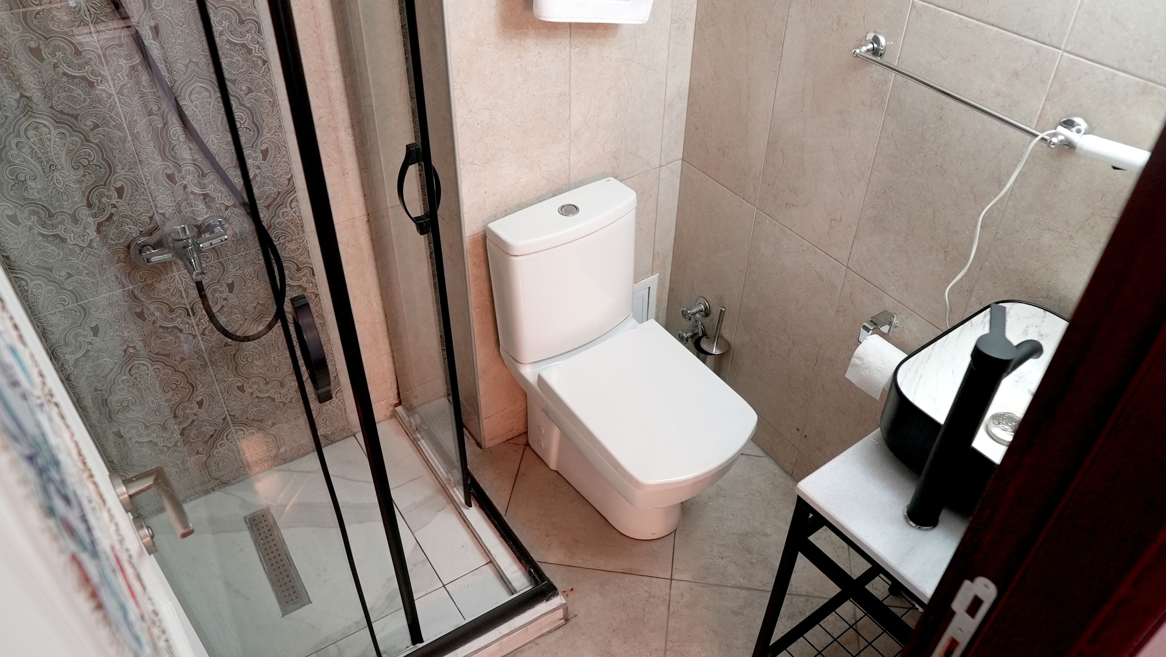 A bathroom with a toilet, a sink, and a shower area.