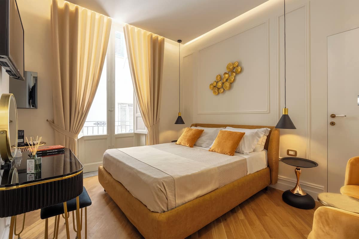 A modern bedroom with a large bed, a desk, and a chair.