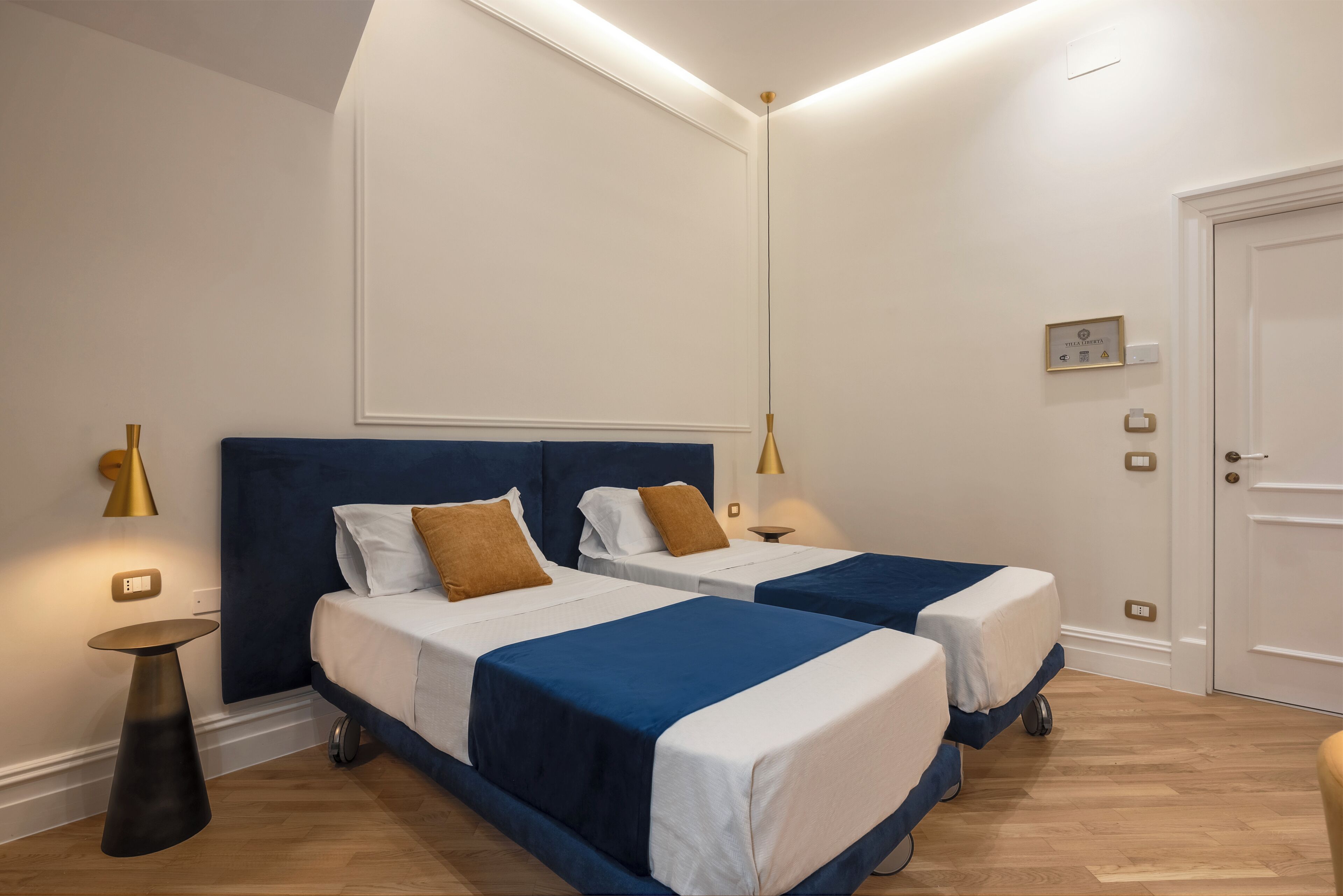 Una habitación de hotel con dos camas, un ventanal grande y una puerta.