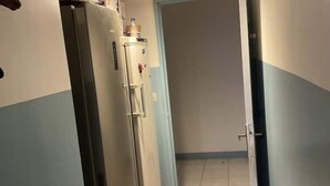 A hallway with a refrigerator and a water dispenser on the wall. - Urban Shelter (Sarvelles)