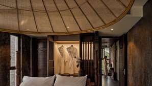 Un dormitorio amplio con una cama grande, una lámpara colgante y vistas al pasillo.