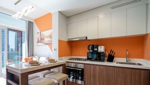 Una cocina moderna con una isla central, horno empotrado y cafetera.
