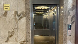 An elevator with a marble wall, a digital display, and a 'Ground Floor' sign. - Hotel Acksia Inn (Udaipur)