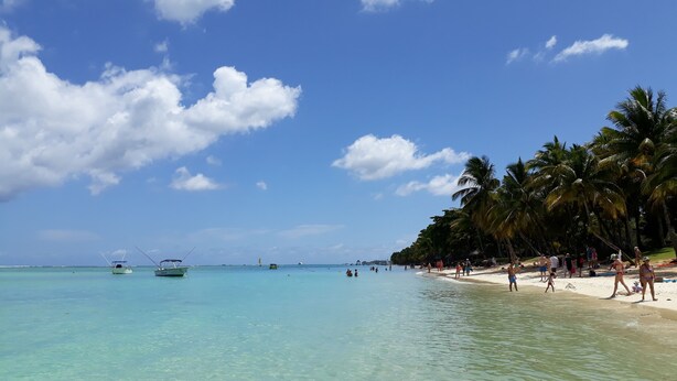 A beach with clear turquoise water, palm trees, and boats. - Appartamento N 7 AL Secondo Piano (Trou aux Biches)