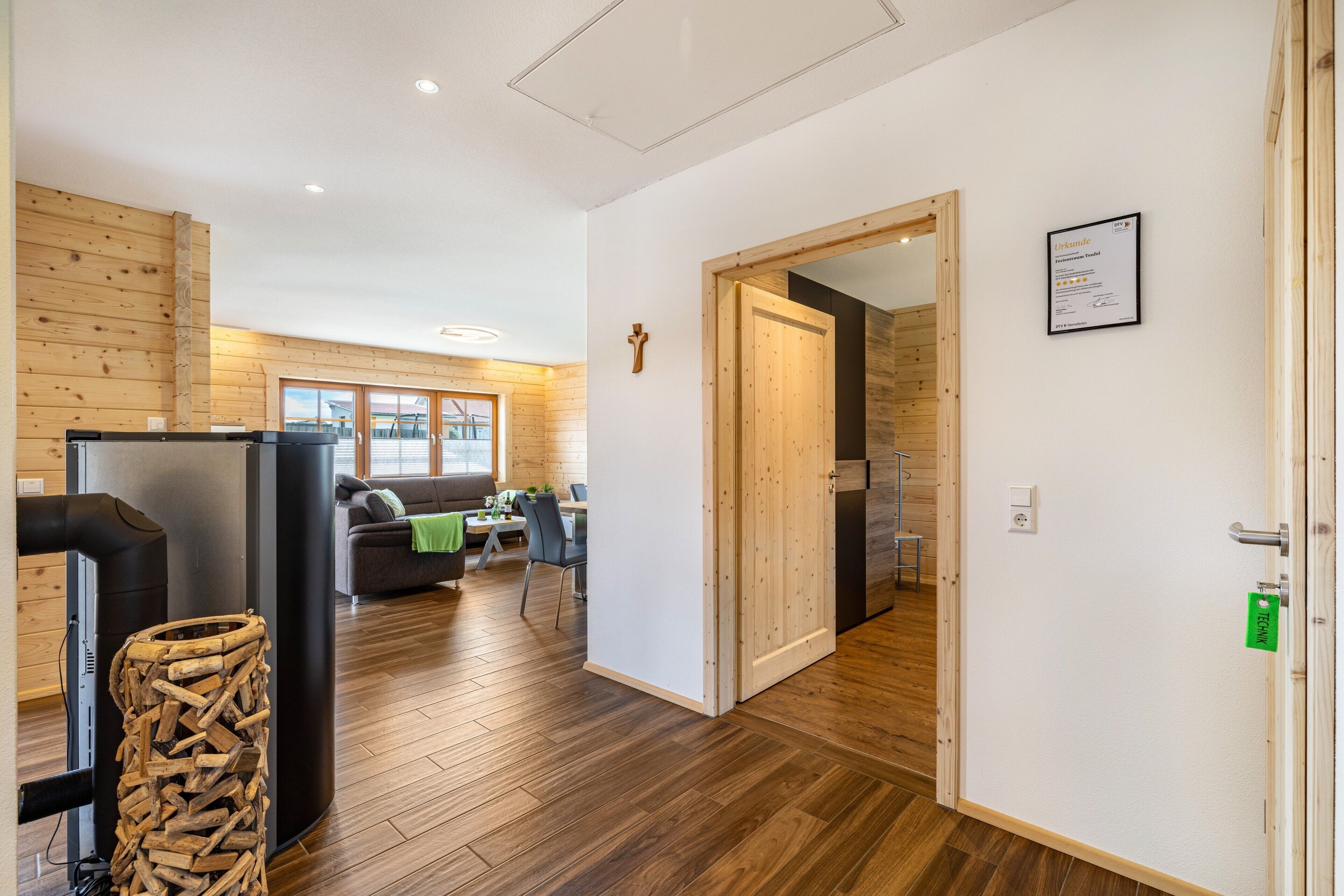 A modern interior with a wooden floor, a dining area, a living room, and a kitchen.