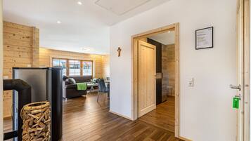 A modern interior with a wooden floor, a dining area, a living room, and a kitchen.