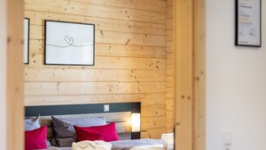 A wooden-paneled room with a bed, pillows, and a framed picture on the wall. - Holiday Home 'Ferienhaus Traum Teufel' with Terrace, Garden and Wi-Fi (Hettingen)