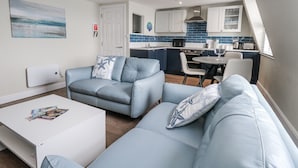 Een knus woongedeelte met een zithoek, een eettafel en een kitchenette.