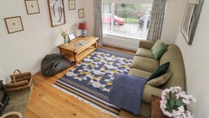 A cozy living room with a sofa, a wooden coffee table, and a patterned rug. - Napton on the Hill - Sleeps Upto 7 & Pet Friendly (Southam)