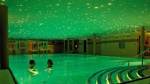 A swimming pool with two people in the water, surrounded by a tiled area with a staircase leading up. - 8 Person Holiday Home on a Holiday Park in Grasten (Grasten)