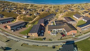 Ein Luftbild einer Küstenstadt mit einer Mischung aus Wohn- und Geschäftsgebäuden, darunter ein großer Parkplatz und ein markantes Gebäude mit der Aufschrift 'Oceanview'.