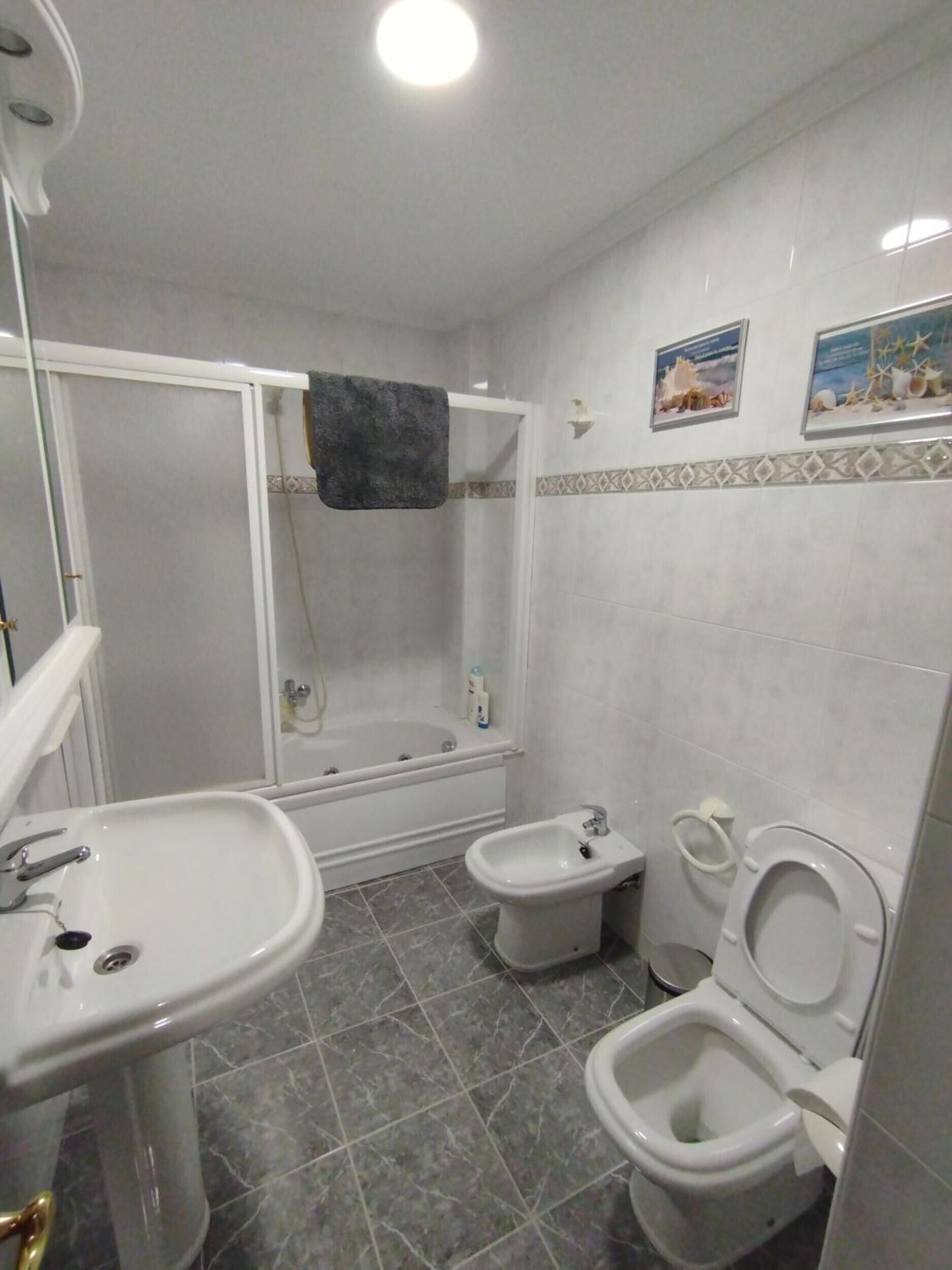 A bathroom with a bathtub, a sink, a bidet, and a toilet.