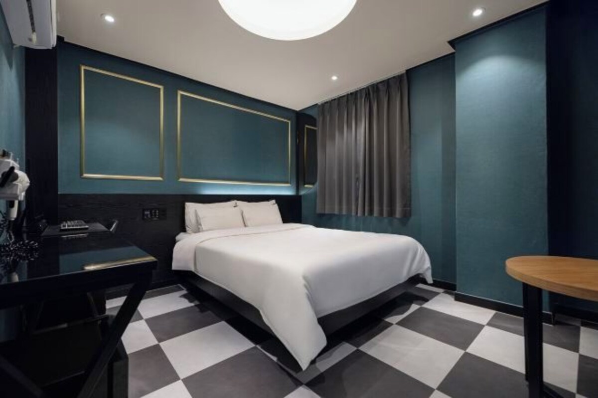 Un dormitorio moderno con una cama, un escritorio y una silla.