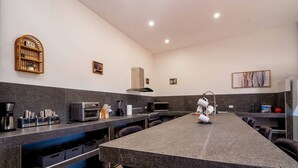 Une cuisine moderne dotée d’un grand îlot central, d’appareils électroménagers intégrés et d’un design épuré et minimaliste.