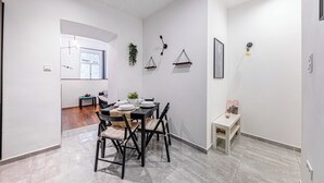 Un comedor moderno con una mesa redonda, sillas negras y una mesita auxiliar.