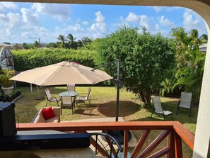 Eine Terrasse mit Tisch, Stühlen und Sonnenschirm.
