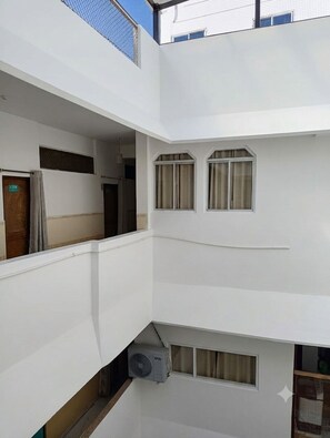 A multi-level building with balconies, windows, and an air conditioning unit. - comfi stay hotel bhopal (Bhopal)