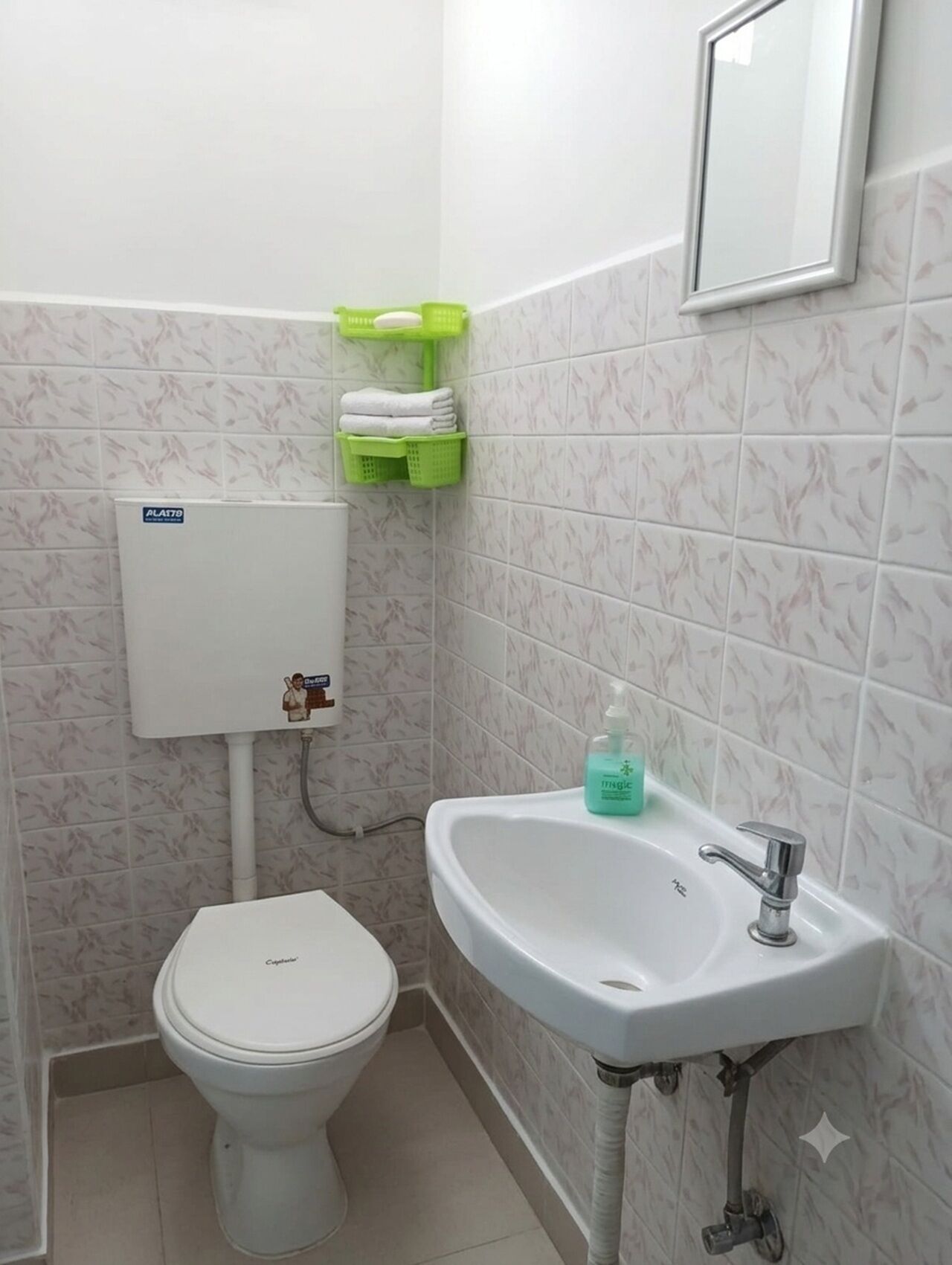 Une petite salle de bain comprenant des toilettes, un lavabo et un porte-rouleau de papier toilette.