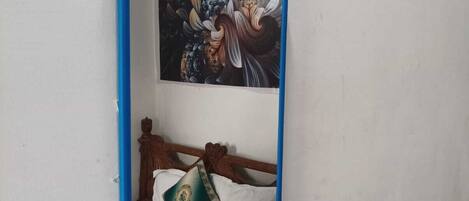 A mirror with a blue frame on a plain wall.